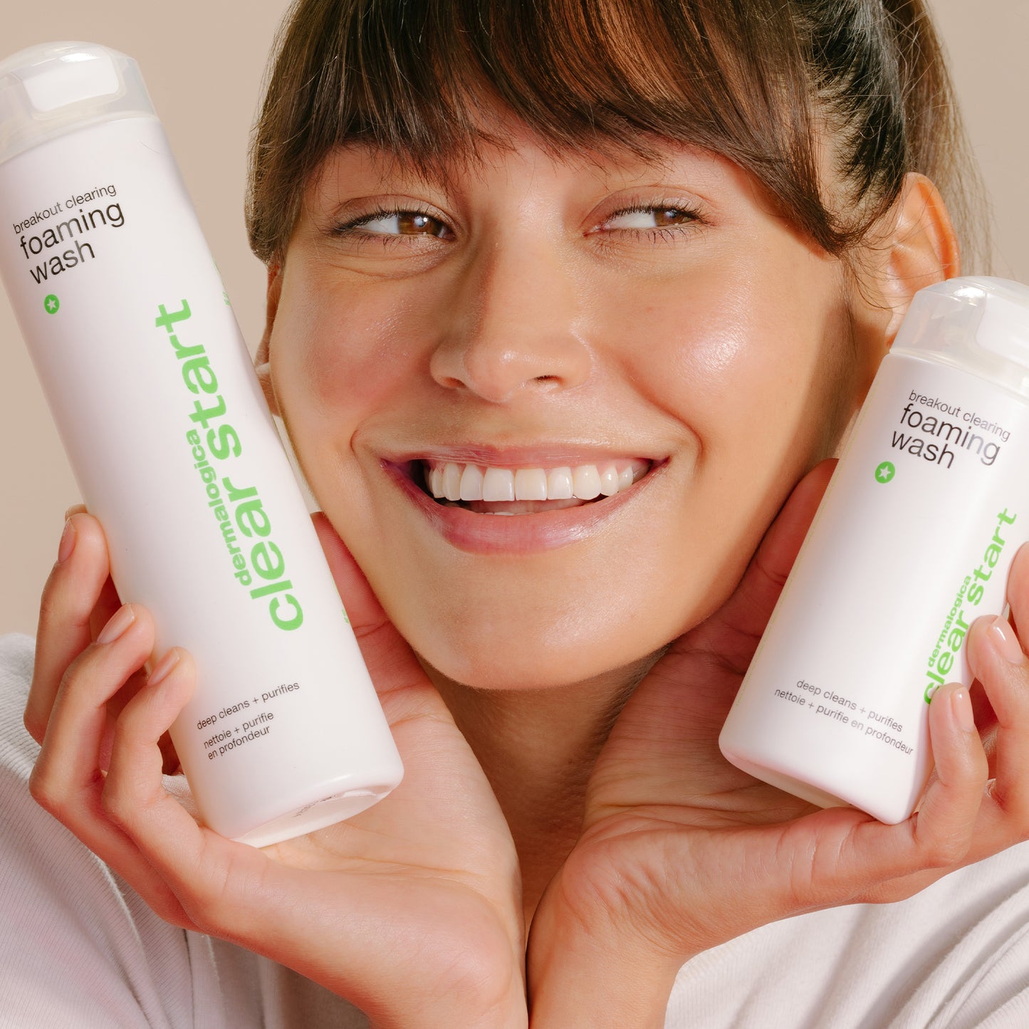 Model holding 10 oz and 6 oz Breakout Clearing Foaming Wash
