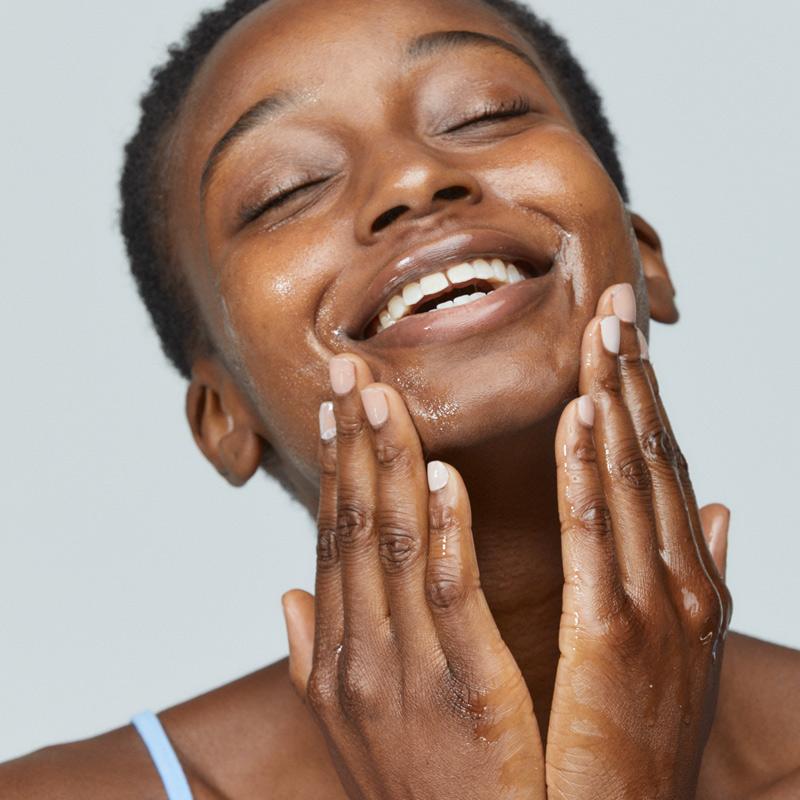 woman cleansing face with precleanse